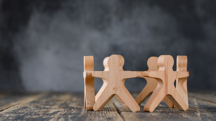 Holzfiguren in einem Kreis auf einer Holzfläche