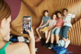 Eine Frau macht ein Foto von Kindern mit einem Smartphone
