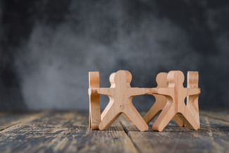 Holzfiguren in einem Kreis auf einer Holzfläche