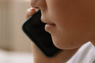 Eine Nahaufnahme einer jungen Person die telefoniert.