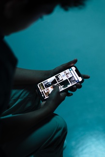 Ein Junge schaut auf seinen Handybildschirm mit Social-Media Inhalten.