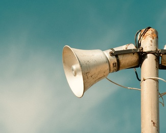 Lautsprecher Stadion weiß vor blauem Himmel